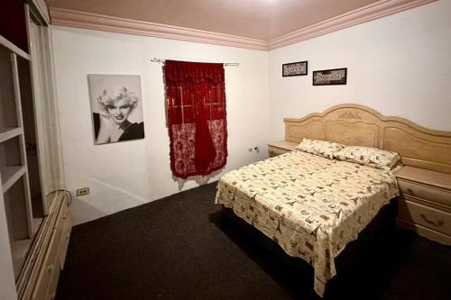 ein Schlafzimmer mit einem Bett und einem roten Vorhang in der Unterkunft Casa en Mexicali in Mexicali