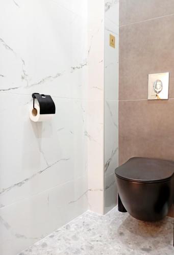 a bathroom with a black toilet and a roll of toilet paper at Domus Vivendi in Chania Town