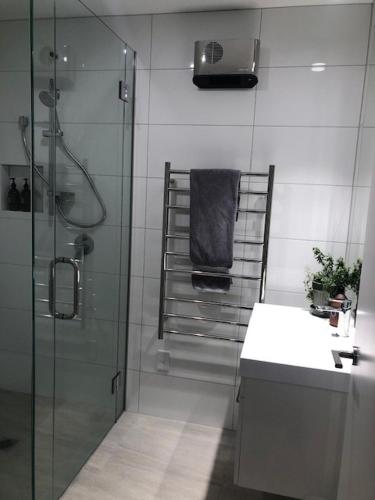 a bathroom with a glass shower and a sink at Mountain View Cottage in Arrowtown