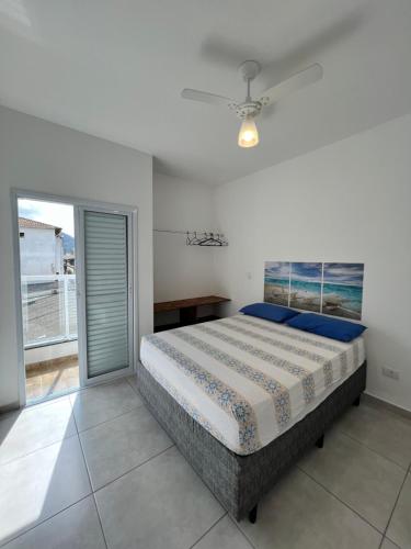 sypialnia z łóżkiem i przesuwnymi szklanymi drzwiami w obiekcie Apê212 - 650m da Orla w mieście Ubatuba