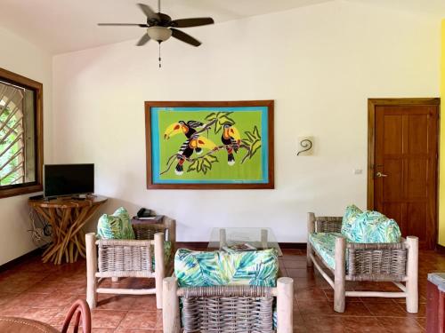 a living room with chairs and a painting on the wall at Cozy AC EcoCondo 4 with Pool Wildlife Visits in Quepos