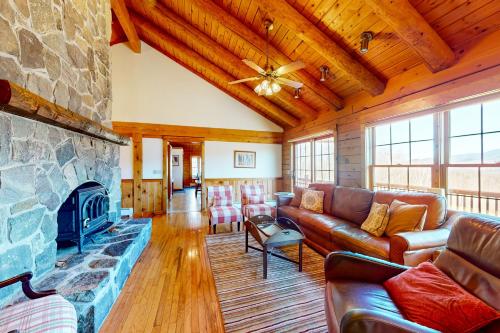 a living room with a couch and a fireplace at Summit Solitude in Franconia