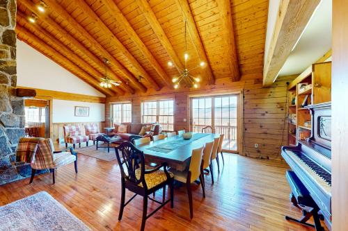 a dining room with a table and a piano at Summit Solitude in Franconia