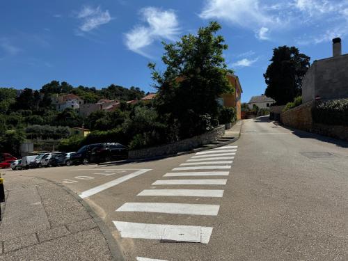an empty street with a crosswalk on the road at Studio Lorena in Mali Lošinj
