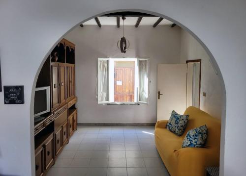 a living room with a yellow couch and a window at SeaDream Appartamento Follonica in Follonica