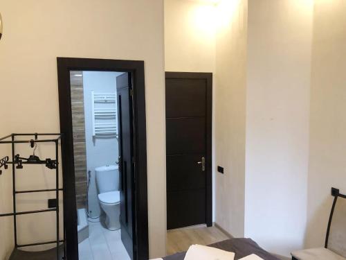 a bathroom with a toilet and a black door at City Center Hotel in Tbilisi City