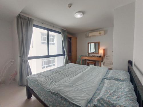 Un dormitorio con una cama y una ventana grande. en Neo Condo Pattaya A709 A209, en Jomtien Beach