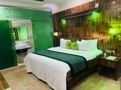 a bedroom with a large bed and a bathroom at St. Regis Hotel & Resort - Benin City in Benin City