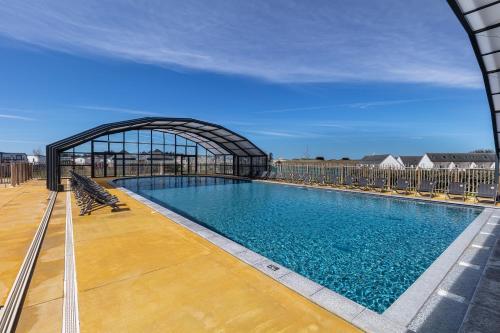 - une grande piscine dans un bâtiment avec une arche dans l'établissement Camping 4 étoiles Piscines et Plage 3 chambres 6 pers - Mallet, à La Turballe