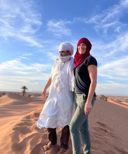 two women are standing in the desert at Mhamid Tours in Mhamid