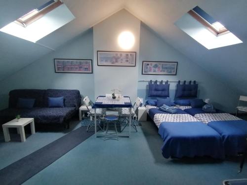 Pokój z 3 łóżkami, stołem i kanapą w obiekcie B&B- La Casa Blu- Forum di Assago, Humanitas, Milanofiori, IEO w mieście Rozzano