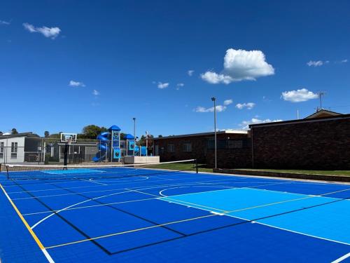 a blue tennis court with a playground on it at BIG4 Tasman Holiday Parks - Warrnambool in Warrnambool