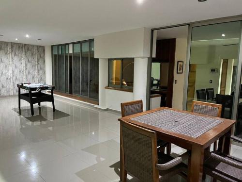a dining room with a wooden table and chairs at Residencia Las Palmas in Colima