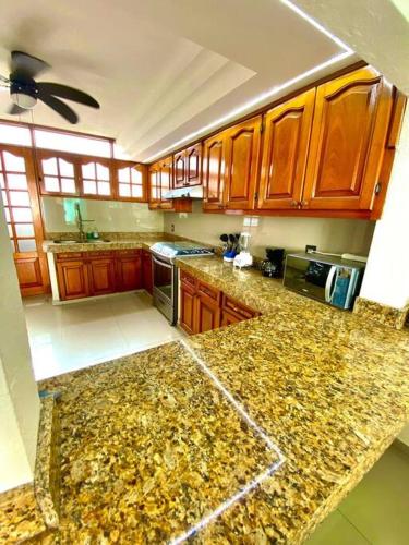 a kitchen with wooden cabinets and a marble counter top at Residencia Las Palmas in Colima