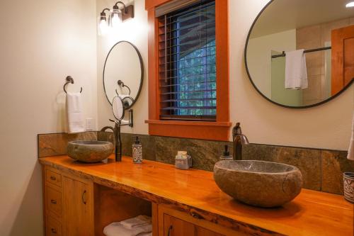 a bathroom with two sinks and a large mirror at Elysian at Mount Baker in Glacier