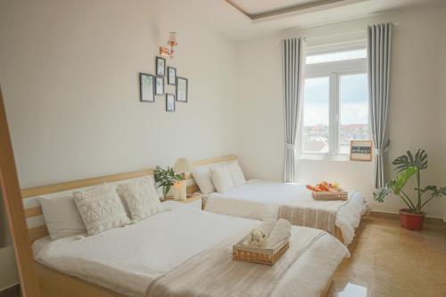 a living room with two beds and a couch at Huong Anh DaLat Palace in Da Lat