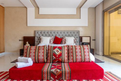 a bedroom with a large bed with a red blanket at Tayyurt Surf Camp Tamraght Aourir in Awrir