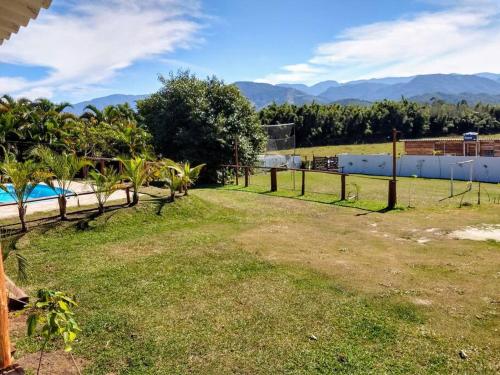 a yard with a fence and a swimming pool at Chácara fortes em Pindamonhangaba in Pindamonhangaba