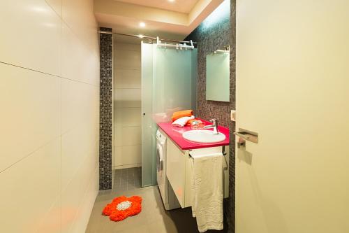 y baño con lavabo rosa y ducha. en Casa Soto Del Ebro, en Tudela