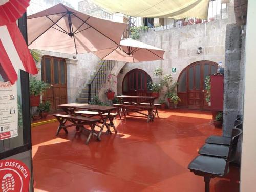 a patio with tables and umbrellas in a building at Hostal Flores in Arequipa