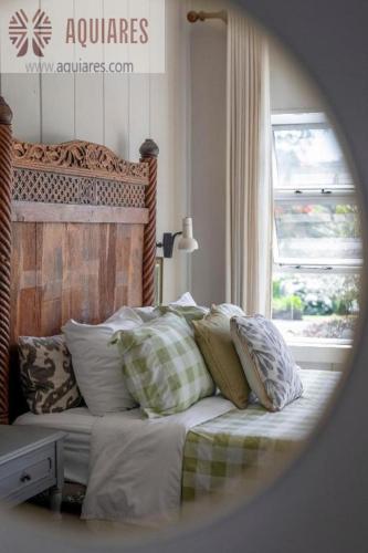 a bedroom with a bed with pillows and a window at AQUIARES COFFEE FARM CASA HACIENDA LA ESPERANZA in Turrialba