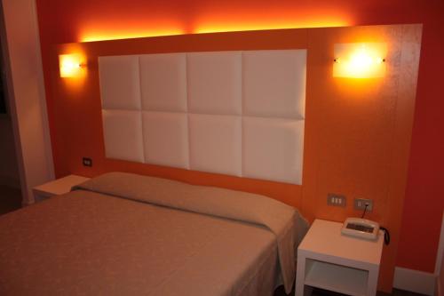 a bedroom with a bed and two lights on the wall at Affittacamere Via Mazzini in Stresa