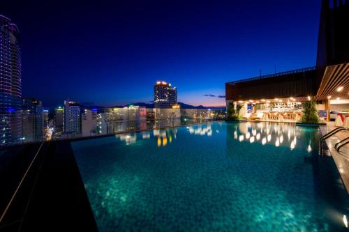 a swimming pool with a city skyline at night at Gonsala Hotel Nha Trang in Nha Trang