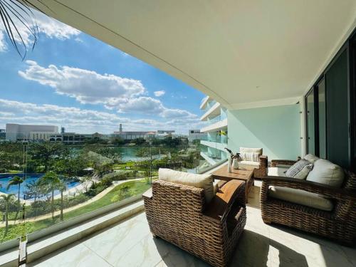 a balcony with two wicker chairs and a large window at Exclusivo y bellísimo condominio en Cabo Norte in Mérida