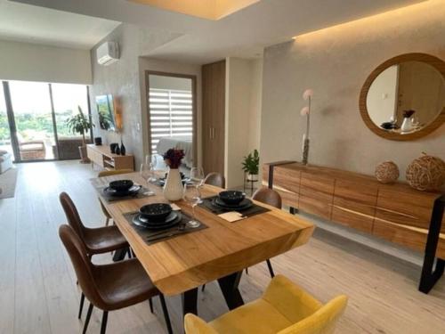 a dining room with a table and chairs and a mirror at Exclusivo y bellísimo condominio en Cabo Norte in Mérida