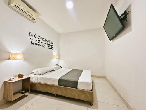 a bedroom with a bed and a tv on the wall at Hotel Boutique Gao in Cúcuta