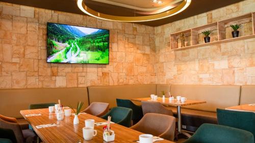 a dining room with tables and a tv on the wall at Holiday Inn Acapulco La Isla by IHG in Acapulco