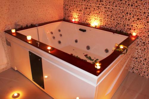 a bathroom with a tub with candles and lights at Riad Mimosa in Fez
