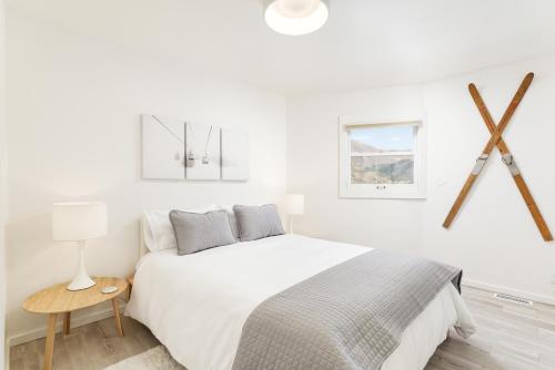 a white bedroom with a large bed and a table at Aspen Ajax Shadow Mountain Lodge in Aspen