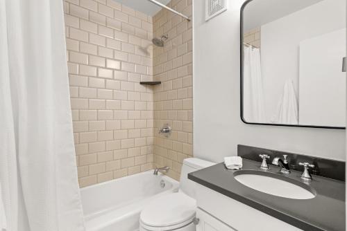 a bathroom with a sink and a toilet and a mirror at Aspen Ajax Shadow Mountain Lodge in Aspen