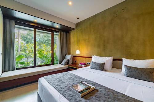 a bedroom with a large bed and a large window at JAPA Suites & Villas in Ubud