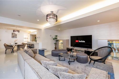 a living room with a couch and a tv at JAPAVISTA Xenith Premium in Osaka