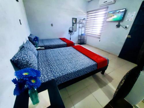sypialnia z 2 łóżkami w kolorze niebieskim i czerwonym w obiekcie Departamento Pacífico w mieście Mazatlán