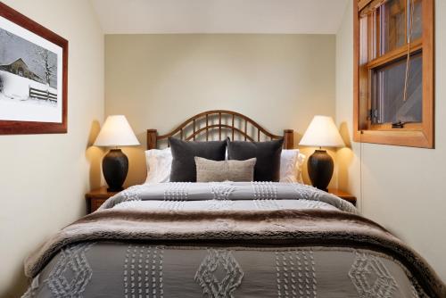 a bedroom with a large bed with two lamps at Summertime Sanctuary Top-floor Mountain Studio in Snowmass Village