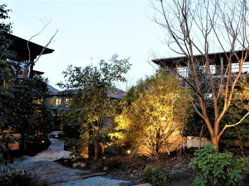 a garden with trees in front of a building at Hotel Morinokaze Hakone Sengokuhara in Hakone