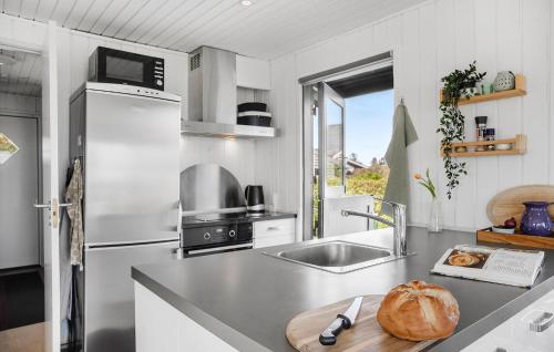 a kitchen with a counter top with a bread on a cutting board at Awesome Home In Børkop in Børkop