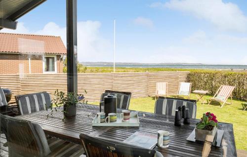 a wooden table and chairs on a patio at Awesome Home In Børkop in Børkop