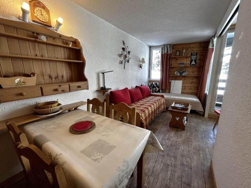 un salon avec une table et un canapé dans l'établissement Studio confortable pour 4 avec vue pistes, Ski-in/Ski-out - FR-1-452-356, aux Menuires