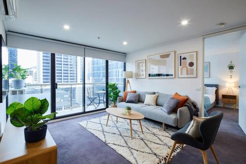 a living room with a couch and a table at 2 Bdrm 2 Bthrm Apt With Parking in Central CBD in Melbourne