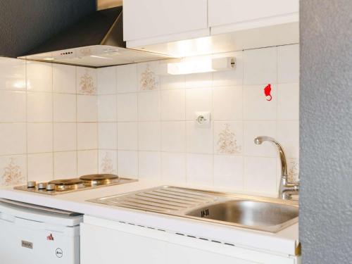 une cuisine avec un évier et une cuisinière dans l'établissement Pavillon 2 pièces mezzanine, piscine proche plage, parking privé - FR-1-409-98, à Narbonne-Plage