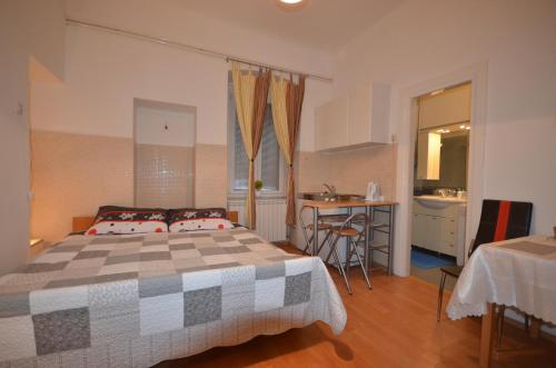 a bedroom with a large bed and a kitchen at Apartment Porto Baross in Rijeka