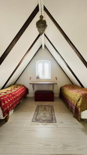 a attic bedroom with two beds and a window at ApartmentInCopenhagen Apartment 1631 in Copenhagen