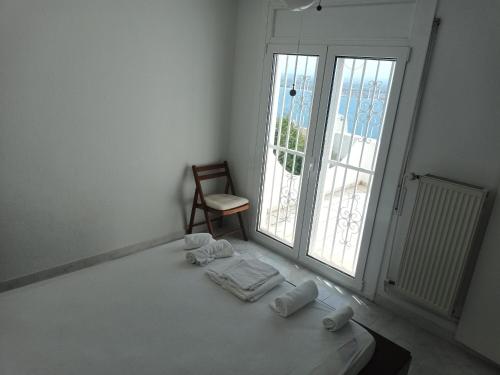 een witte kamer met een bed, een stoel en ramen bij Casa Roses, 4 dormitorios, 7 personas - ES-258-136 in Roses