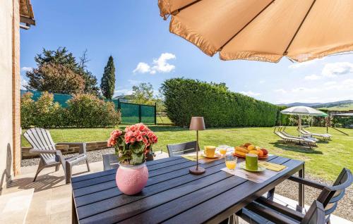 a wooden table with a vase of flowers on a patio at Casa Muzzi Verde in Casole dʼElsa