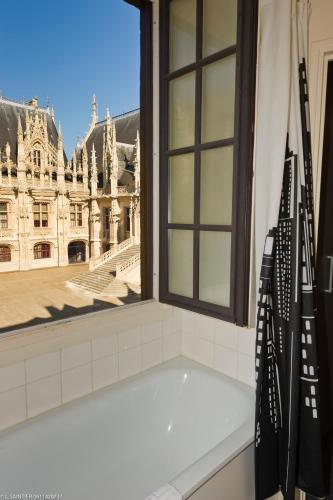 a bath tub in a bathroom with a window at Les Initiés in Rouen