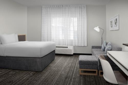 Habitación de hotel con cama y sofá en TownePlace Suites Sacramento Cal Expo en Sacramento